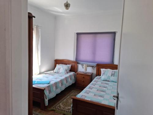 a bedroom with two beds and a purple window at Casa do Vale in Arrabal