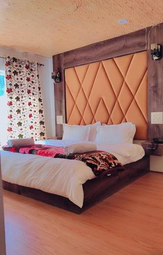a bedroom with a large bed with a large headboard at Snow Touch Pahalgam in Pahalgām