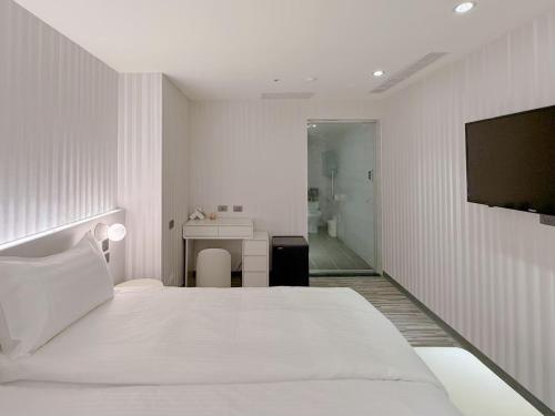 a white bedroom with a bed and a bathroom at 在家行旅 南西館 in Taipei