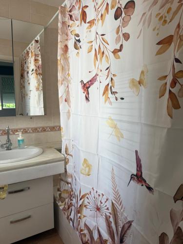 a bathroom with a shower curtain with fish on it at Villa con Piscina climatizada in Sanlúcar de Barrameda