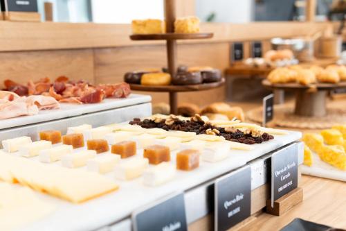 a display of cheese and pastries in a bakery at Arenas Atiram Hotel in Barcelona