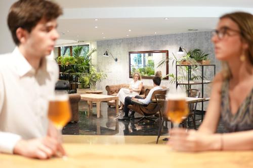a group of people sitting at a table with drinks at Arenas Atiram Hotel in Barcelona