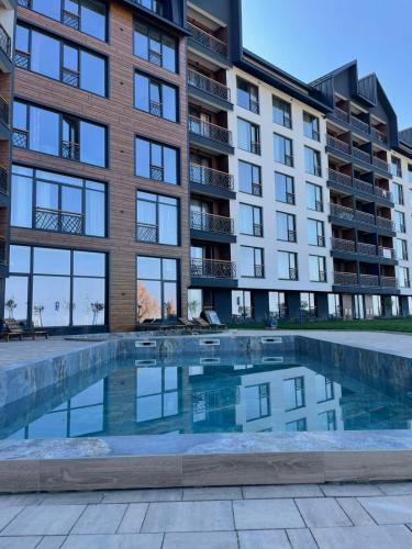 an apartment building with a pool in front of it at VAB Apartments & SPA, Residence hill, Kopaonik in Kopaonik