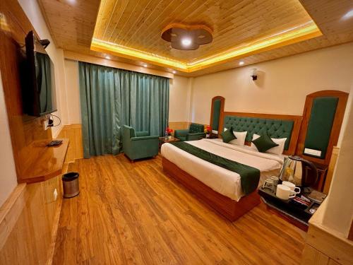 a bedroom with a large bed and a television at Hidden Heaven Waterfall view in Manāli