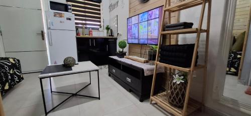 cocina con encimera, mesa y nevera en AN edom suite, en Eilat