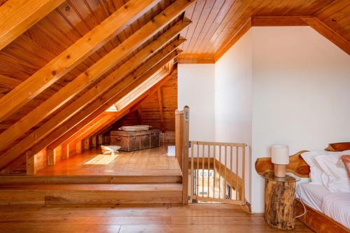 an attic room with a staircase and wooden ceilings at GuestReady - Exceptional house near Colares in Colares
