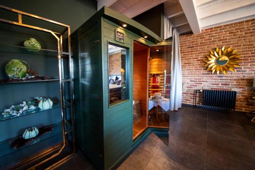 a hallway with a green door and a brick wall at Golden Eye Suite in Saint-Vith