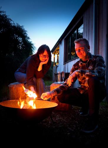 a man and a woman sitting next to a fire at The Dell at Glenlivet in Glenlivet