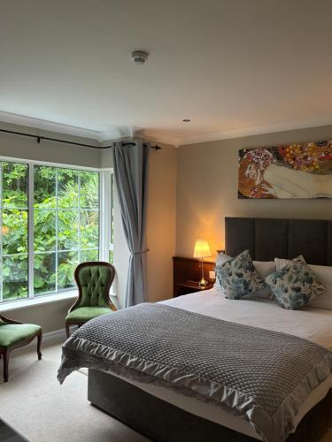 a bedroom with a bed and a large window at The Grove Lodge Guesthouse in Killorglin