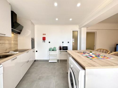 a kitchen with white cabinets and a dishwasher at Albufeira Amazing View With Pool by Homing in Albufeira