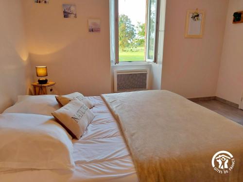 a large bed in a room with a window at GITE LE PLESSIS in Gennes-sur-Glaize