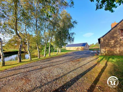 an empty road next to a barn and trees at GITE LE PLESSIS in Gennes-sur-Glaize