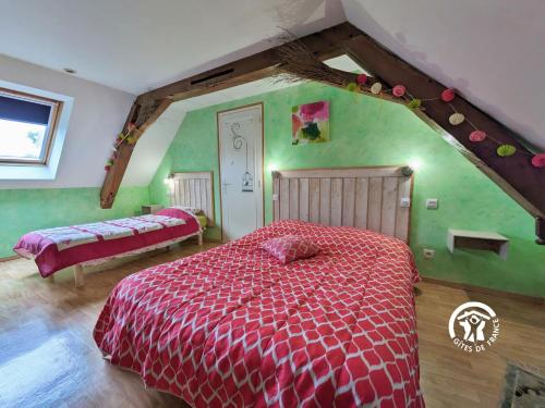 a bedroom with a red bed and green walls at La Hérissière in Bazouges