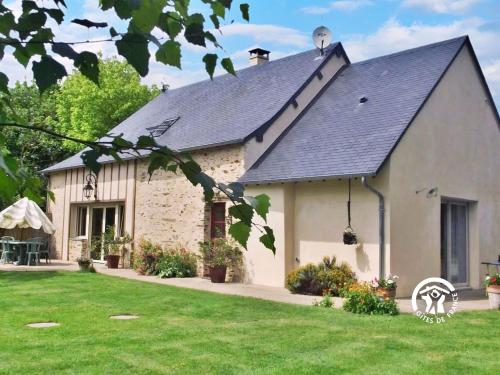a white building with a black roof at La Hérissière in Bazouges
