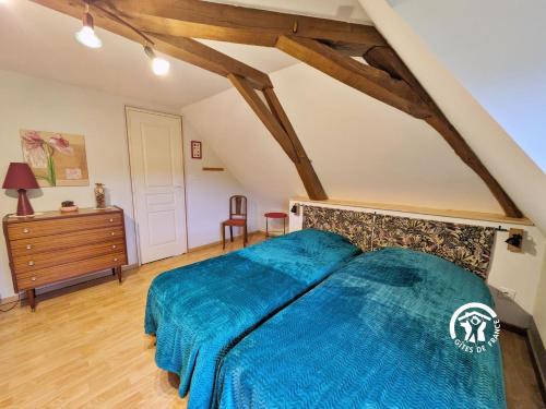 a bedroom with a blue bed in a attic at La Hérissière in Bazouges