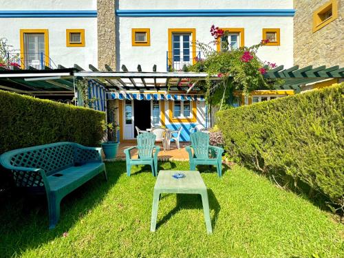 a yard with chairs and a table in the grass at Monte Gordo Vila Verde by Homing in Castro Marim