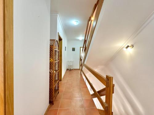 a hallway with stairs leading to a room with wine racks at Monte Gordo Vila Verde by Homing in Castro Marim