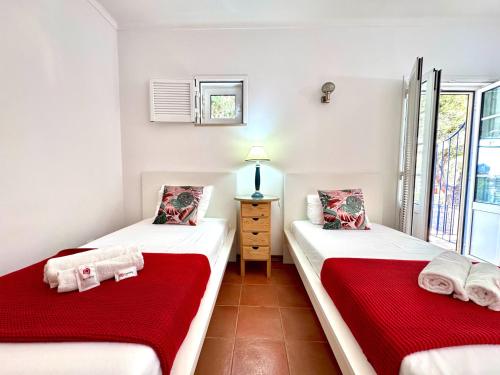 two twin beds in a room with a window at Monte Gordo Vila Verde by Homing in Castro Marim