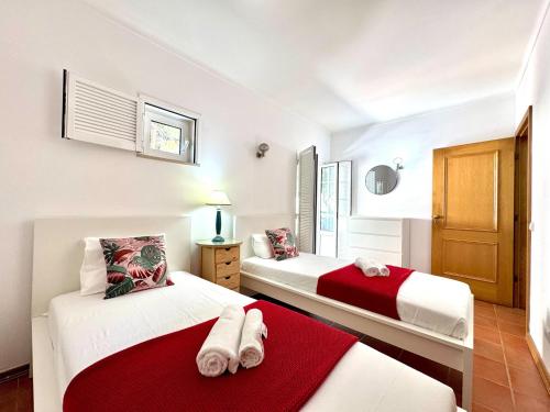 two beds in a room with white and red at Monte Gordo Vila Verde by Homing in Castro Marim