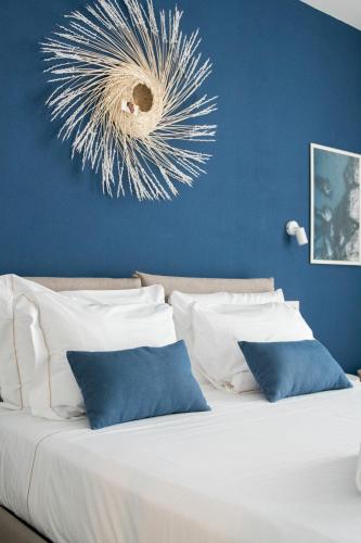 a bedroom with a white bed with a blue wall at Delphis Pula Rooms in Pula