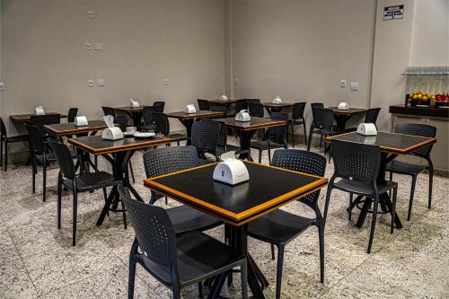 une salle de classe avec des tables et des chaises avec des serviettes dessus dans l'établissement Norte Hotel, à Taiobeiras