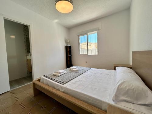 a bedroom with a large bed with two towels on it at Villa with Pool, Chill-Out & BBQ in Torrevieja