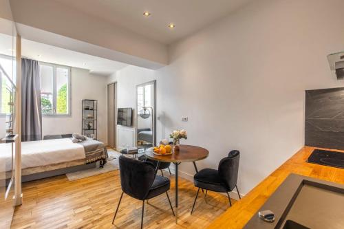 una stanza con un letto, un tavolo e delle sedie di Studio Charming & Modern a Biarritz