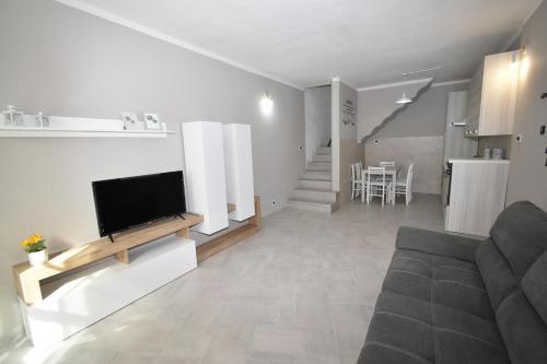 Una sala de estar con un sofá y un televisor en una pared. en Pisa & Lucca Dream Stay, en Avane