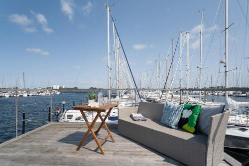 Un banco y una mesa en un muelle con barcos. en Hausboot Coworkingship, en Burgtiefe auf Fehmarn 