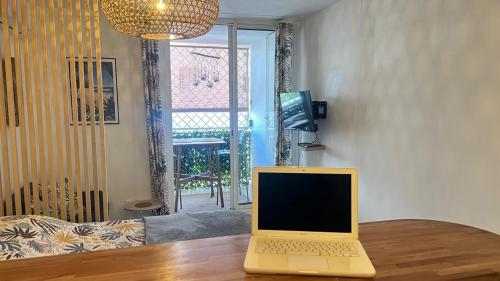 a laptop sitting on a wooden table in a living room at Le Ti'Sun in Saint-Paul