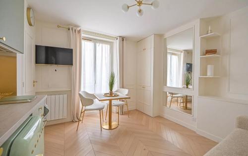 une cuisine avec une table et des chaises dans une pièce dans l'établissement Chez Lucette Studio 17e Paris, à Paris
