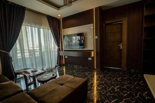 a living room with a couch and a television at Presken Hotels, Awolowo Way, Ikeja in Ikeja
