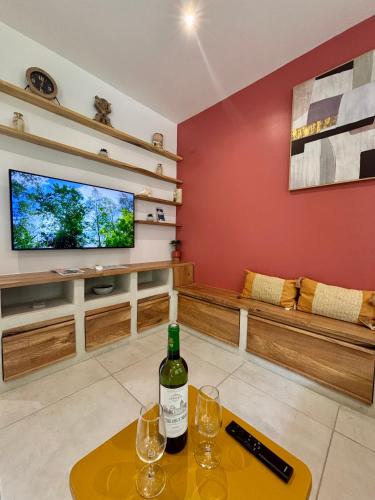a living room with a bottle of wine on a table at Sunset Dream - Bungalow haut de gamme proche Plage in Grand-Bourg