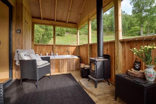 a room with a fireplace and a tub in a cabin at The Dell at Glenlivet in Glenlivet