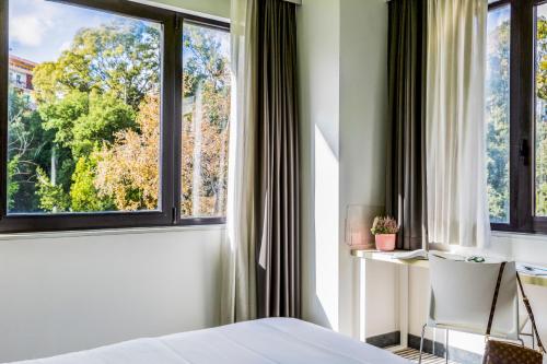 een slaapkamer met een groot raam en een stoel bij The Caesar Roma in Rome