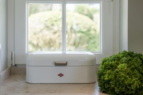 a white suitcase sitting in front of a window at Hiidbloom - Hüs im Wattweg in Kampen