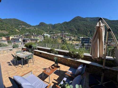a patio with an umbrella and a table and chairs at Casa Marsal - Proap Apartments in Encamp