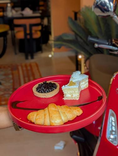 um prato vermelho com diferentes tipos de sobremesas. em The LC Hotel em Lahore