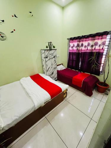 a bedroom with two beds and a window at ADH Amilia Nest in Mysore