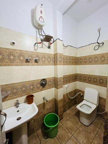 a bathroom with a white toilet and a sink at ADH Amilia Nest in Mysore