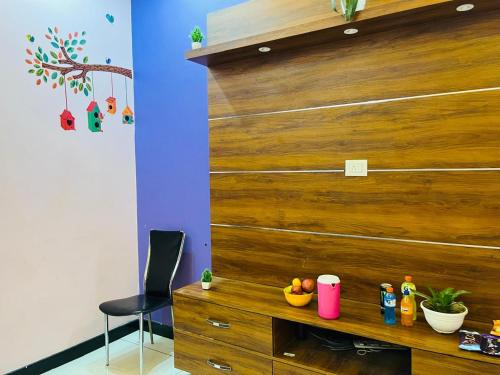 a room with a wooden wall and a table with fruit on it at ADH Amilia Nest in Mysore