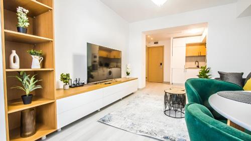a living room with a large television and a green couch at YamaLuxe Luxury Apartments - București in Bucharest