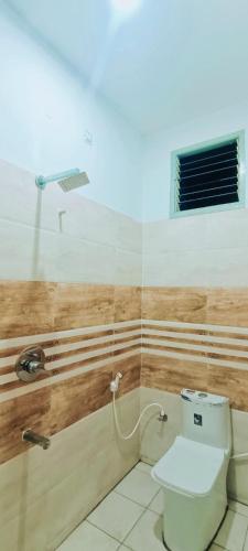 a bathroom with a toilet and a sink at ADH Amilia Nest in Mysore