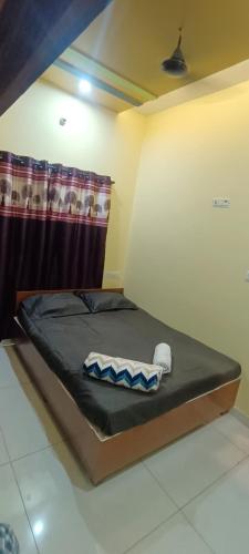 a small bed in a room with a curtain at ADH Amilia Nest in Mysore