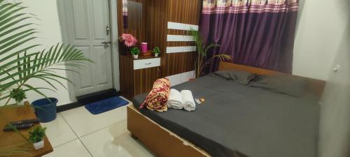 a bedroom with a bed and plants in it at ADH Amilia Nest in Mysore