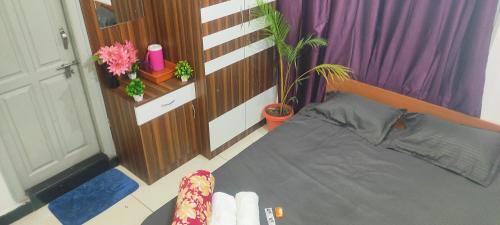 a small bedroom with a bed and purple curtains at ADH Amilia Nest in Mysore