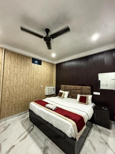 a bedroom with a large bed with a ceiling fan at Hotel Ayodhya International in Ayodhya