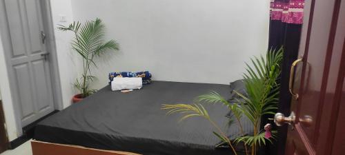 a bed in a room with potted plants at ADH Amilia Nest in Mysore