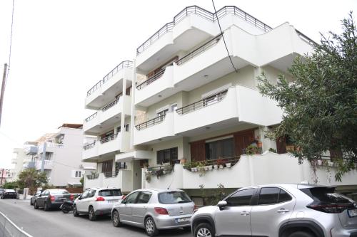 a white building with cars parked in front of it at City Center Luxury Spacious apt A&M II in Rhodes Town