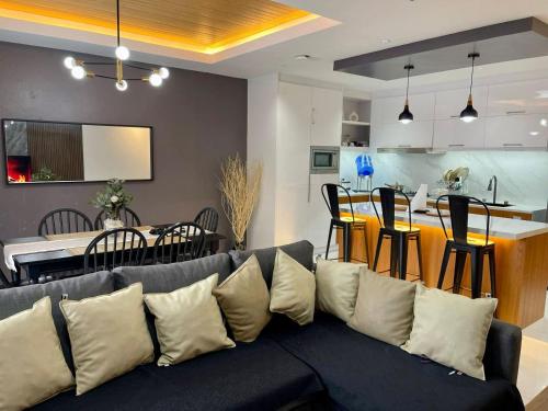 a living room with a blue couch and a kitchen at Yanna's Unit - 3Bedroom with Breakfast in Baguio